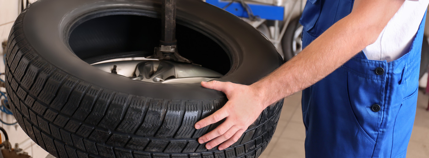 Mechanic holding a car tyre - Tyres Colchester